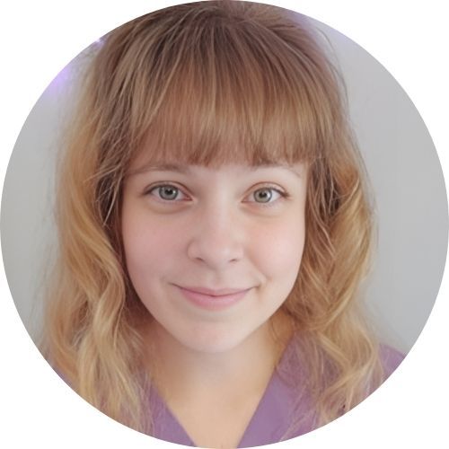 Smiling person with wavy, light brown hair and bangs, wearing a purple top, looking directly at the camera.